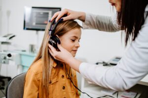 Audiologist performing a hearing test on a young girl | hearing test in Wenatchee | Horan & Fevold